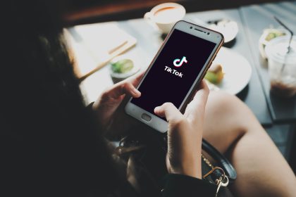 Bangkok. Thailand. MAY 24,2023 : woman using Phone showing TikTok application on screen and laptop, TikTok is popular social media network and entertainment / Shutterstock