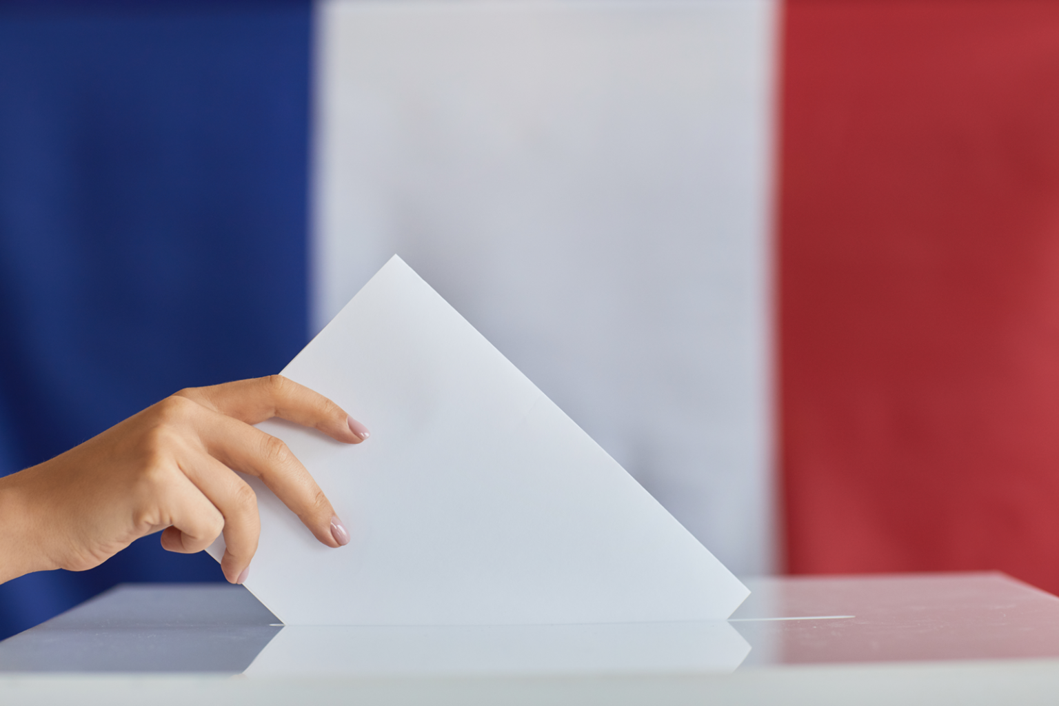 Hand Placing Ballot in Election Box with Flag/AnnaStills/Envato