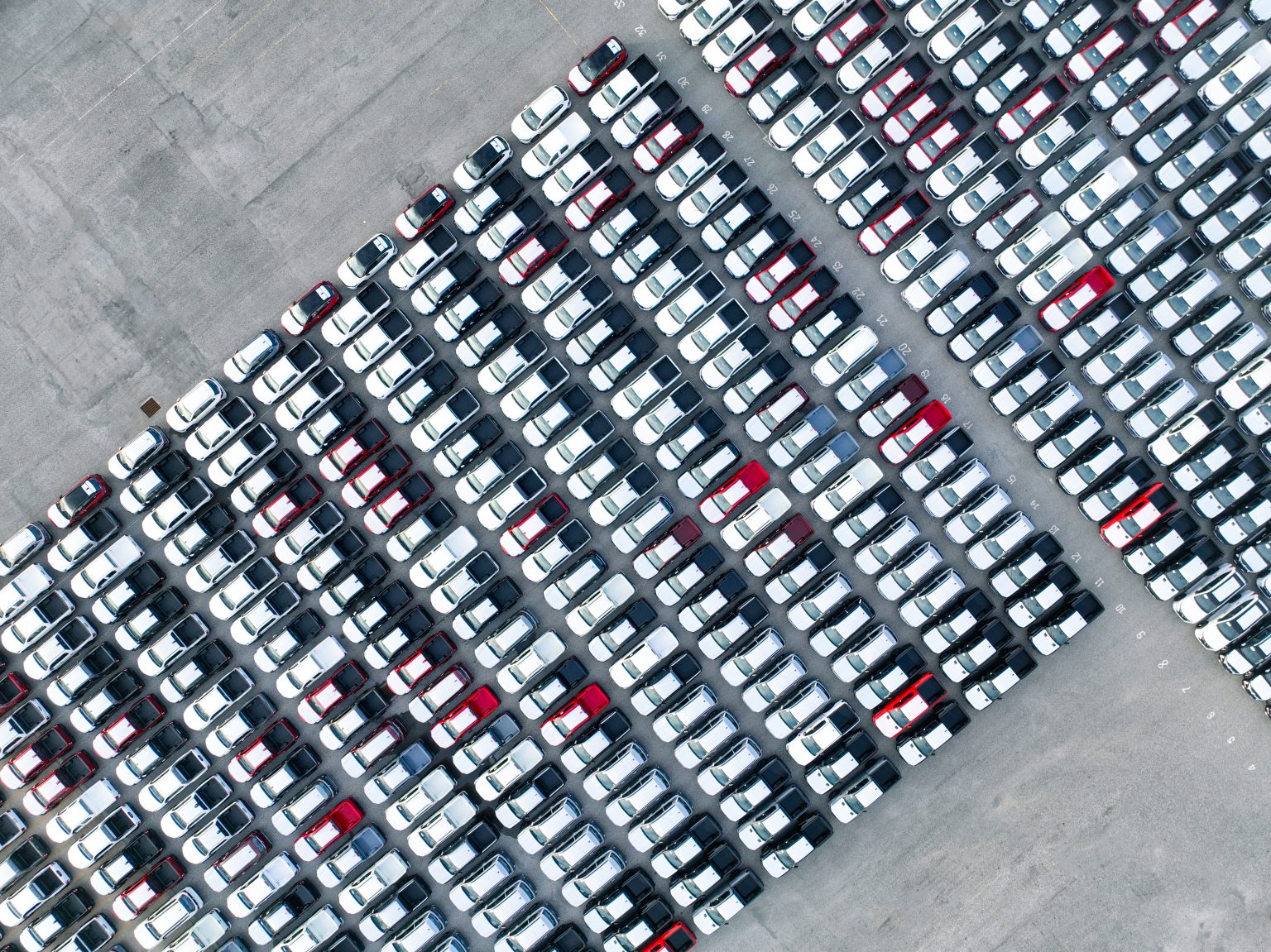 Aerial view of new cars stock at factory parking lot / Envato