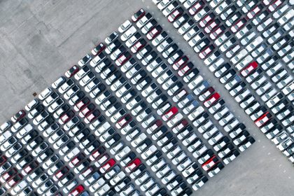 Aerial view of new cars stock at factory parking lot / Envato
