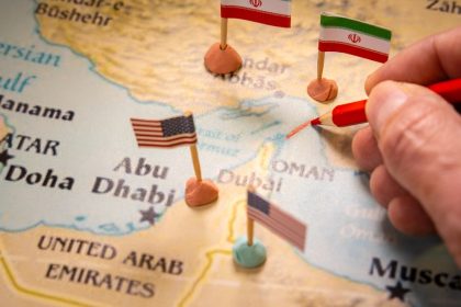 Conceptual image of a hand drawing a red line on a map of the Middle East with United States and Iran flags/Ivan Marc/Shutterstock