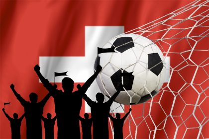 Silhouetted Fans Cheering Soccer Goal with Swiss Flag/FotoFeast/Envato